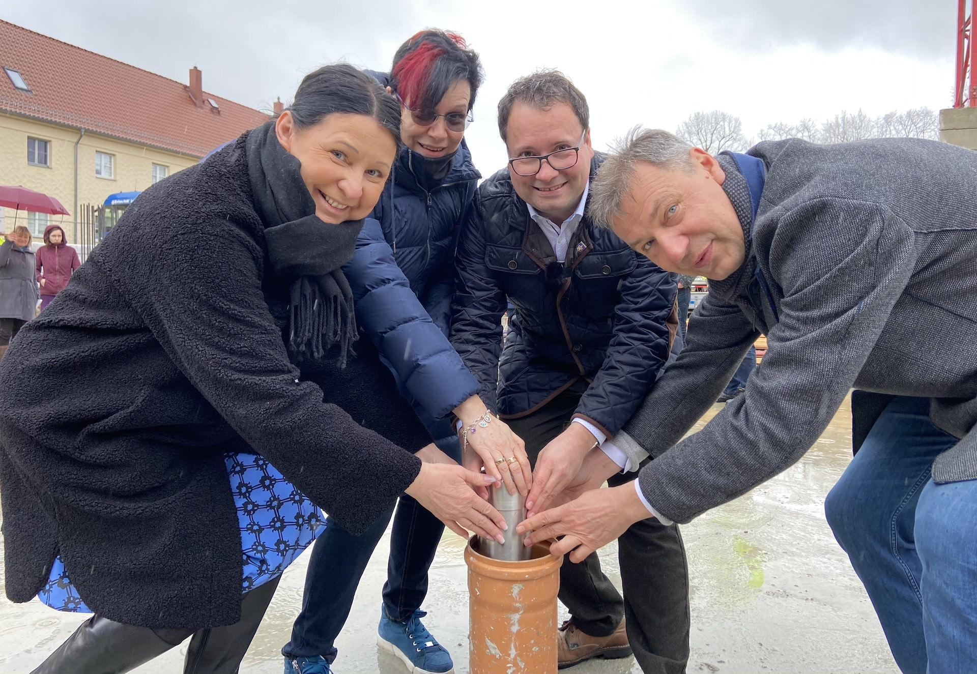 Sie platzierten die Hülse mit wichtigen Zeitdokumenten im Grundstein der neuen Sporthalle: Landrat Kai Emanuel, Bürgermeister Tobias Meier, Oberschul-Leiterin Kathrin Beer, sowie Kathrin Theil-Schultze, Leiterin der benachbarten Regenbogenschule (v.r.) (Foto: taucha-kompakt.de)