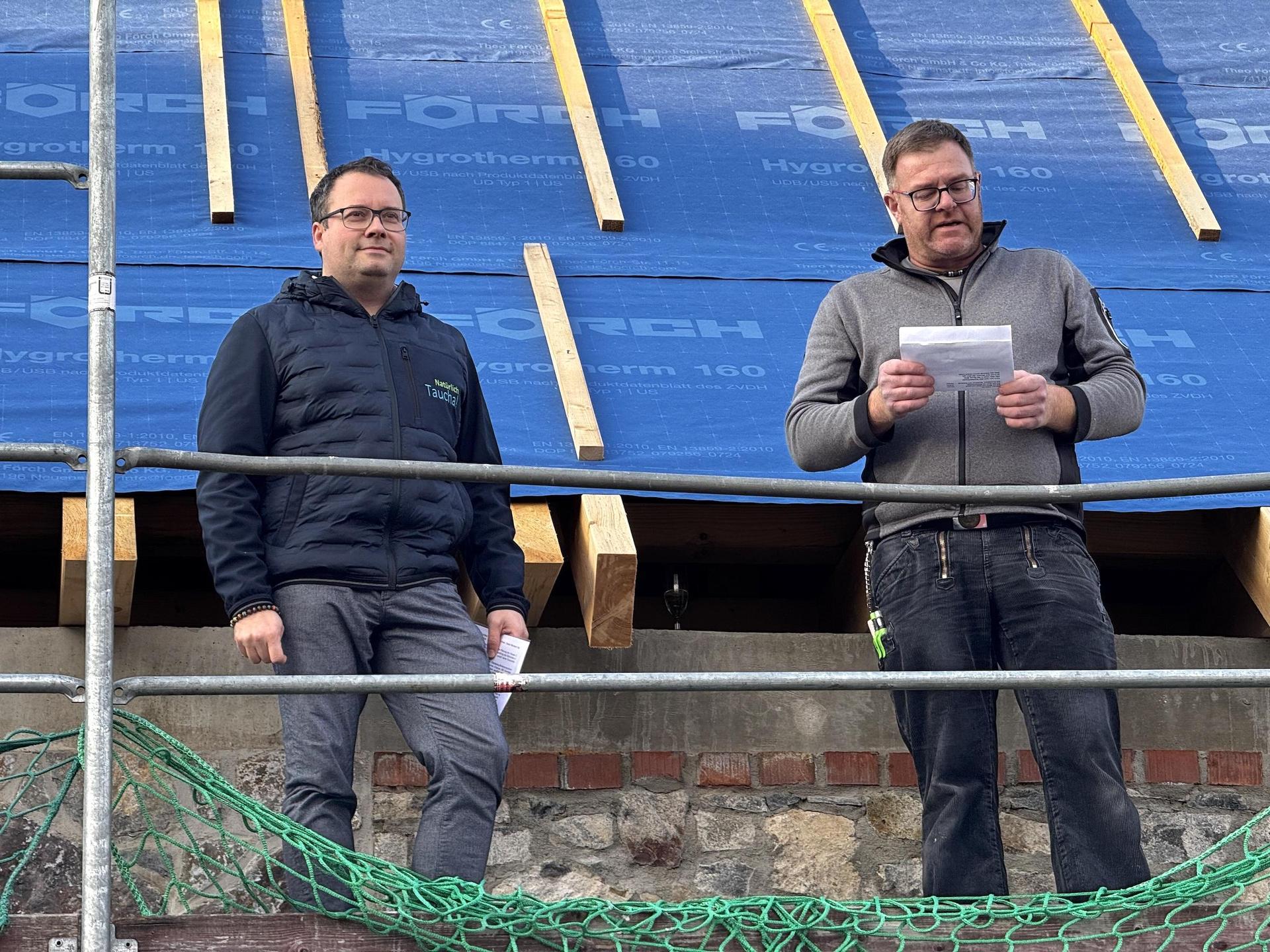 Zimmermann René Augustin verlas den Richtspruch und stieß danach mit Bürgermeister Tobias Meier auf den Neubau an. (Foto: Daniel Große)
