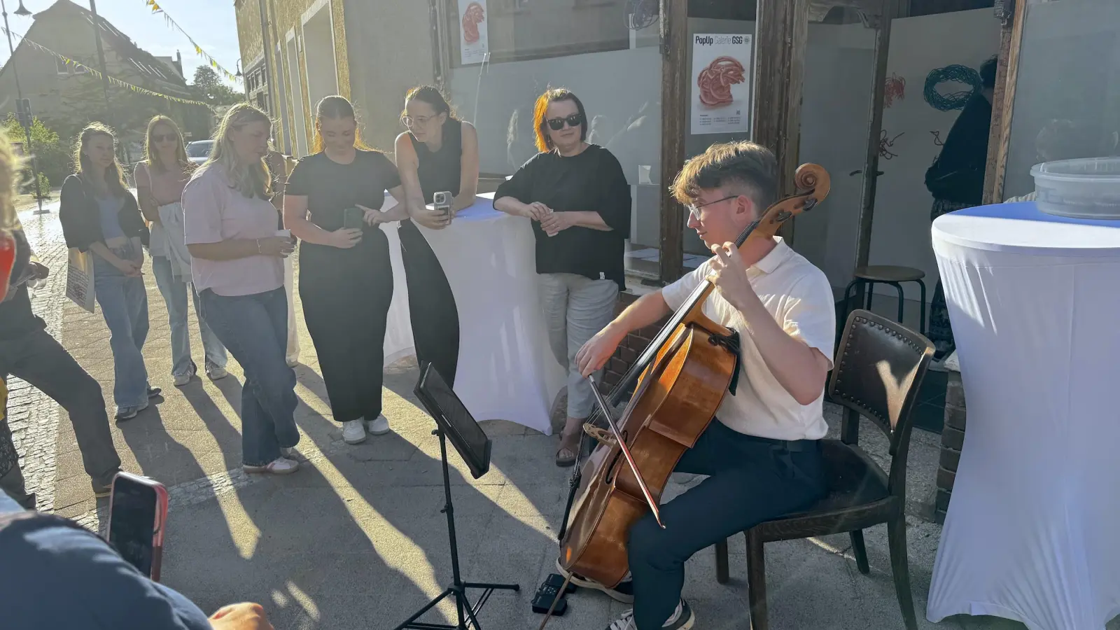 Zacharias Bogner am Cello und später Shyona Frank am Sopran-Saxophon gaben zur Midissage ein kleines Konzert auf dem Fußweg. (Foto: Daniel Große)