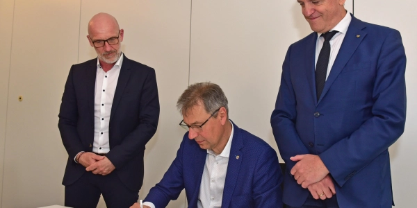 Landrat Kai Emanuel unterzeichnet im Beisein von WGD-Geschäftsführer André Planer (l.) und Oberbürgermeister Manfred Wilde (r.) den Mietvertrag. 				 (Foto: Foto: LRA/Bley)