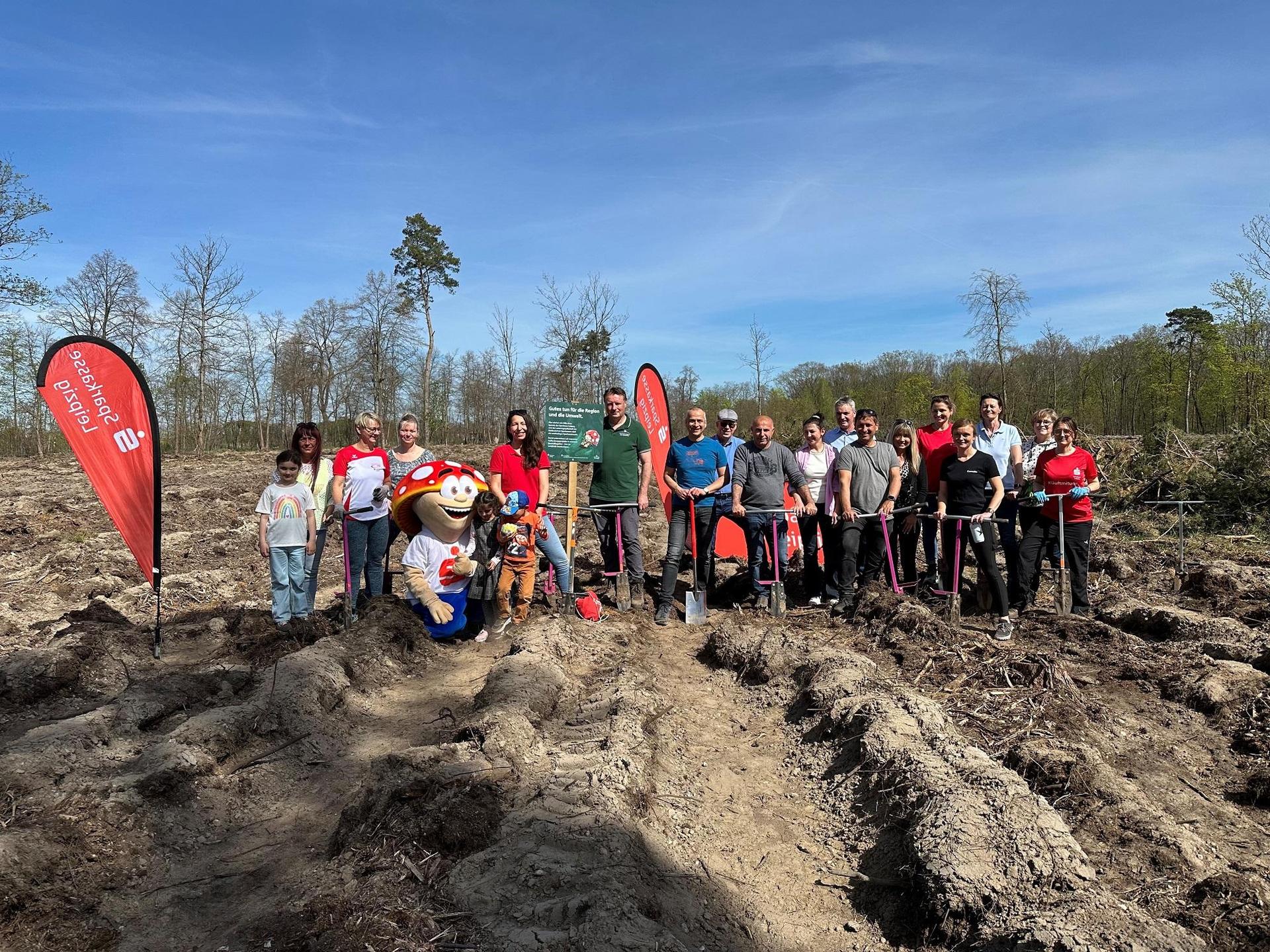 Firmenkunden und Berater der Sparkasse Leipzig sowie deren Familien beim Arbeitseinsatz im Delitzscher Stadtforst. In der Bildmitte: Michael Tiedtke, Vertriebsdirektor bei der Sparkasse Leipzig (blaues T-Shirt), und Henrik Lindner, Geschäftsführer der Stiftung Wald für Sachsen (grünes T-Shirt). (Foto: Sparkasse Leipzig)