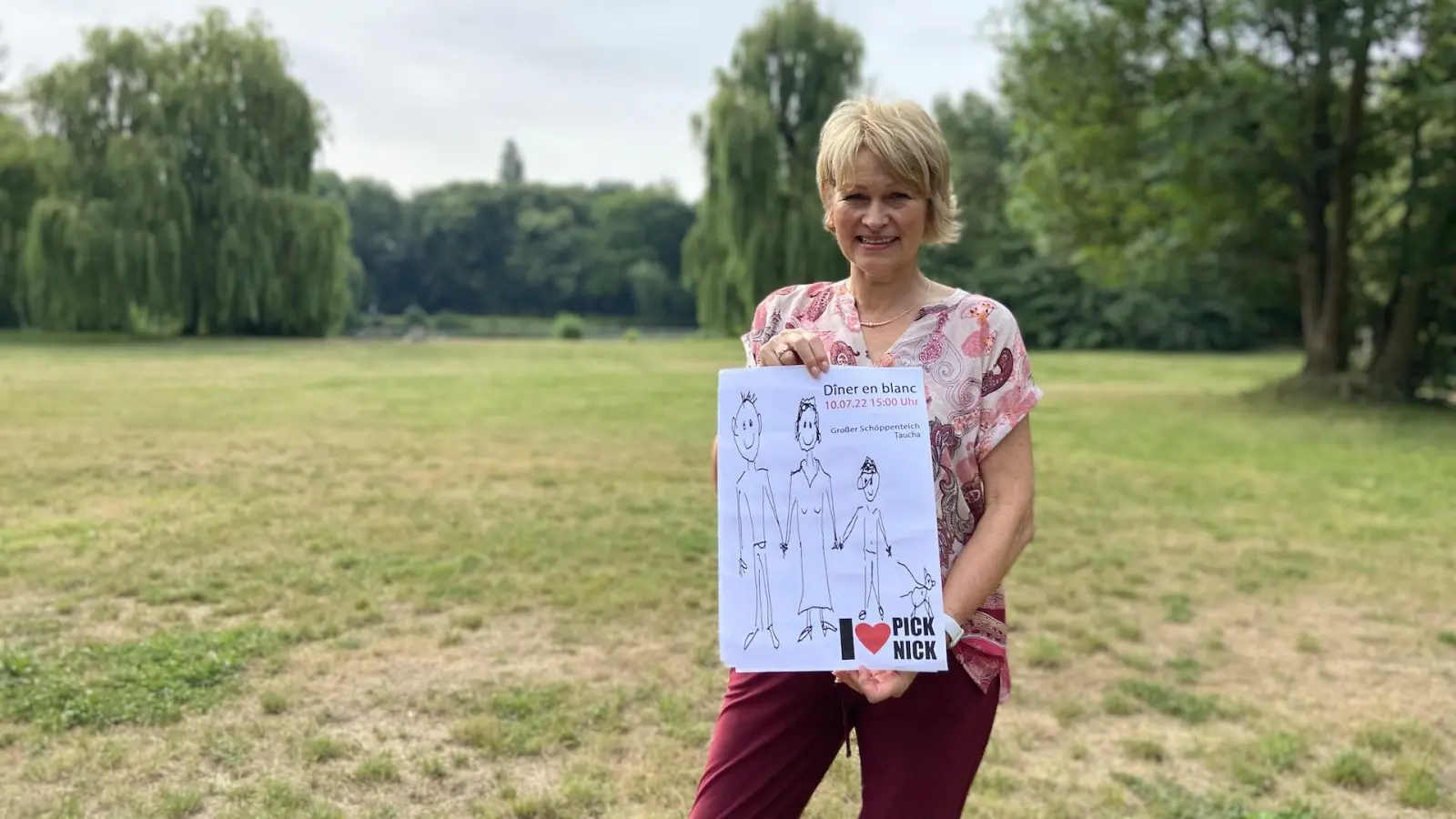 Karin Bell zeigt das Veranstaltungsplakat (Foto: taucha-kompakt.de)