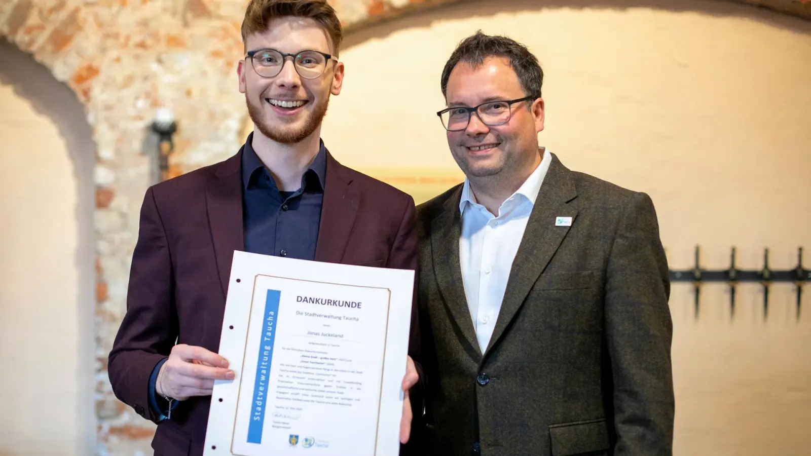 Jonas Juckeland mit der Dankurkunde der Stadt Taucha, die Bürgermeister Tobias Meier ihm überreichte. (Foto: David Sievers)