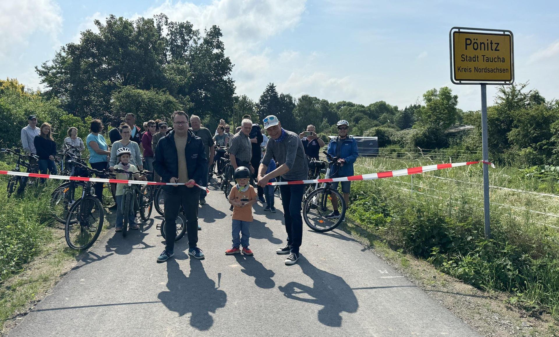 Ein symbolisches Band zerschnitten Bürgermeister Tobias Meier (l.) und Landrat Kai Emanuel zur Eröffnung des Radwegs. Dabei bekamen sie auch Hilfe von Kinderhänden. (Foto: Daniel Große)